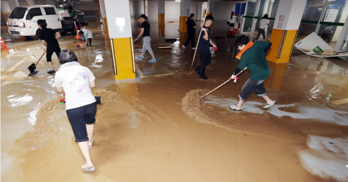 Người dân dọn nước lũ tại một cơ sở y tế ở tỉnh Jeolla Nam, Hàn Quốc, ngày 4/8/2025. (Ảnh: Yonhap/TTXVN)