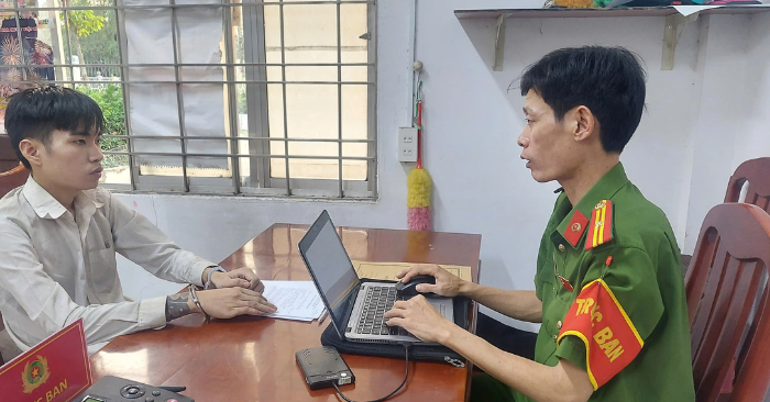 Nguyễn Chí Thiện (trái) tại trụ sở công an (Ảnh chụp màn hình)