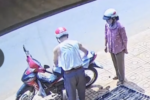 Người chồng cởi áo, lót yên xe cho vợ giữa trưa nắng