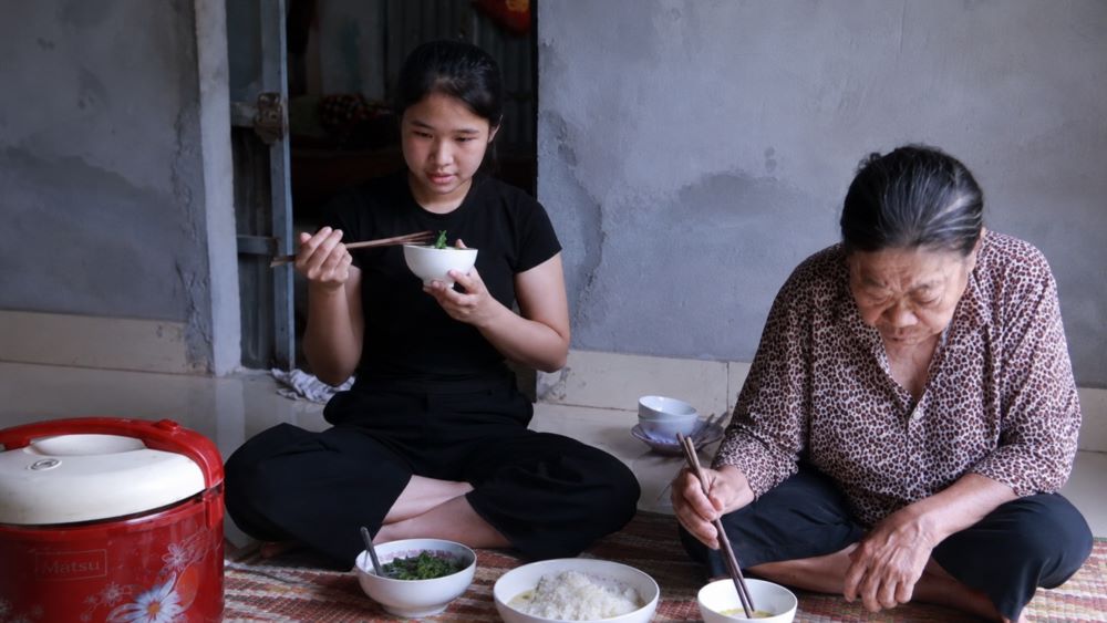 Bữa cơm đạm bạc của mẹ con Xuyến với rau luộc, phản ánh hoàn cảnh khó khăn và ước mơ vào đại học của cô bé mồ côi cha.