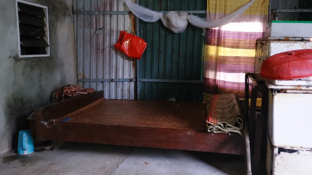 Căn nhà nghèo chỉ có chiếc giường cũ, phản ánh hoàn cảnh khó khăn của cô bé mồ côi cha nuôi ước mơ đại học.